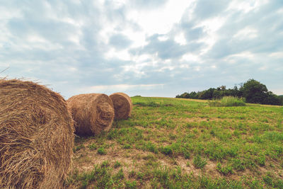 Hay bales on field against sky