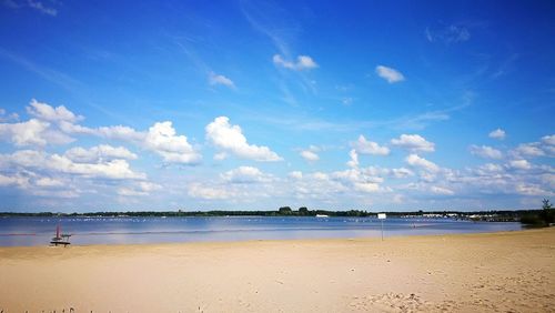 Scenic view of beach against blue sky