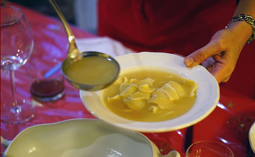 Midsection of man preparing food in bowl on table