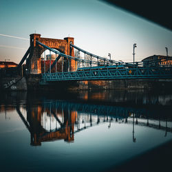 Reflection of illuminated bridge over river