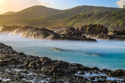 Scenic view of sea and mountains against sky