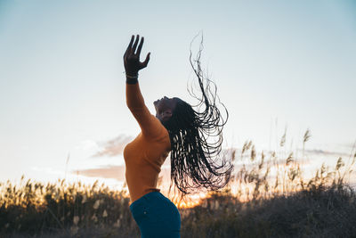 Rear view of woman standing against sky