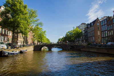 Bridge over river in city against sky