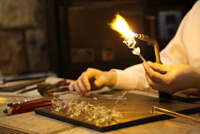 Midsection of man making glass art at workshop