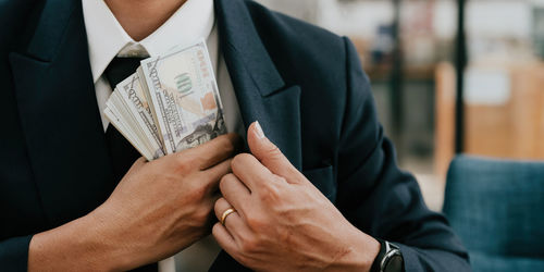 Midsection of businessman using mobile phone