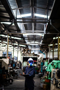 Mature man using laptop in factory