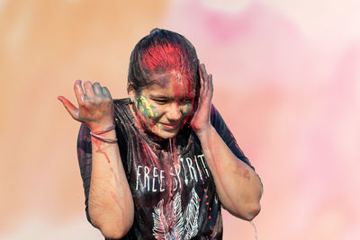 Aide view of happy young girl with color on face playing holi