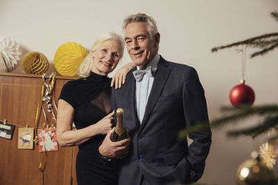 Senior couple holding bottle of champagne on new yera's eve