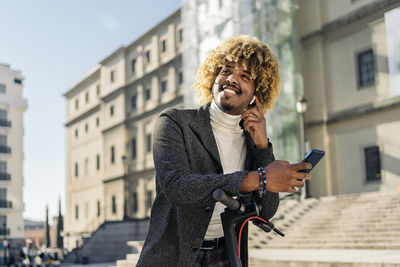 Full length of man using mobile phone in city