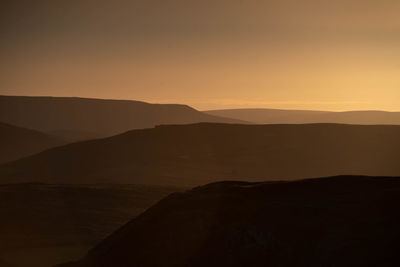 Scenic view of silhouette mountains against sky during sunset