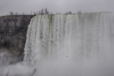 Scenic view of waterfall against sky