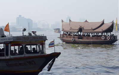 Boats in river against sky