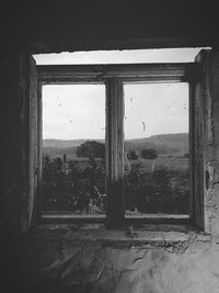 Buildings seen through window of abandoned house