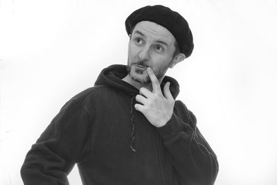 Portrait of young man standing against white background