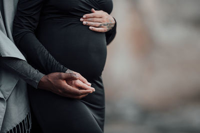 Midsection of woman standing by tree