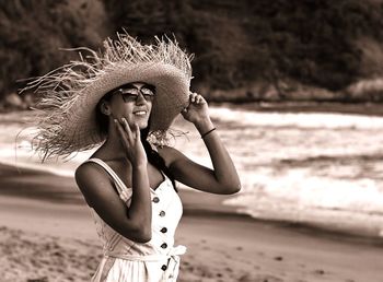 Young woman wearing hat standing at beach