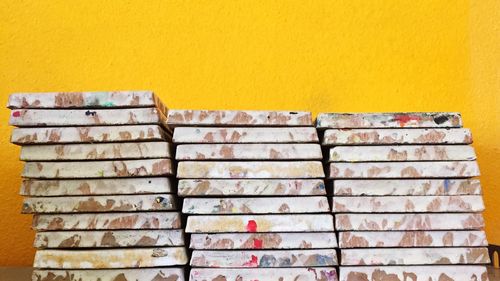 Stacked tiles against yellow wall