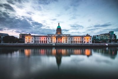 Reflection of building in river against sky