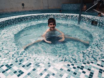 Portrait of shirtless man swimming in pool