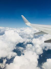 Cropped image of airplane flying over clouds