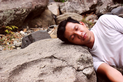 Young man relaxing on rock