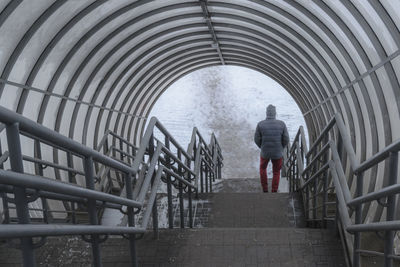 Rear view of man going down on staircase