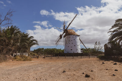 Traditional windmill on field against sky