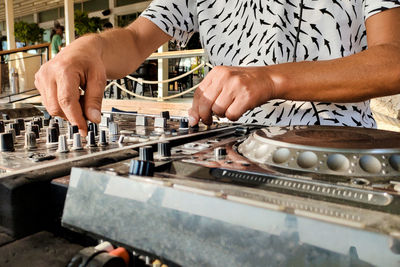 Turkey, alanya - august 12, 2022, dj plays on dj console mixer, hands and turntable closeup