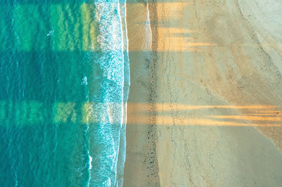 Top view of a sandy beach on the ocean shore. yellow sand, blue water