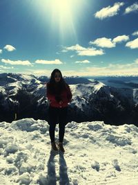 Full length of man standing on snowcapped mountain against sky