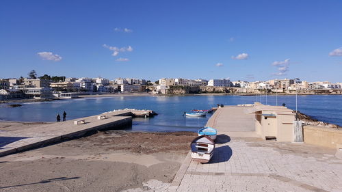 Boats moored on sea against blue sky