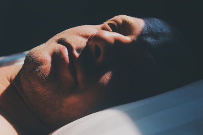 Sunlight falling on thoughtful mid adult man lying on bed