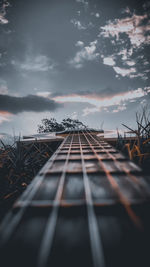 Close-up of guitar against sky during sunset