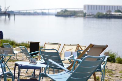 Empty chairs by lake