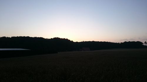 Scenic view of silhouette field against clear sky during sunset