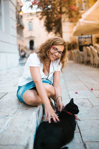 Woman with dog sitting outdoors