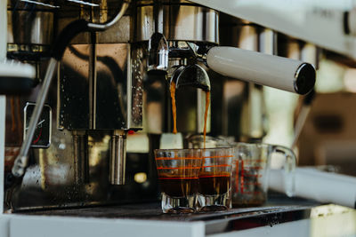 Espresso shot coffee flows from the coffee machine.