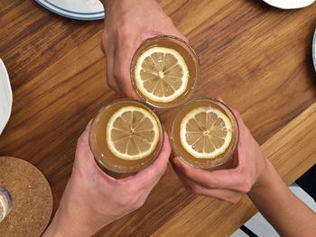 High angle view of men toasting lemonade on table