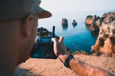 Portrait of man photographing sea