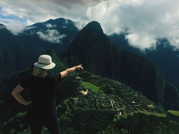 Woman pointing against mountain