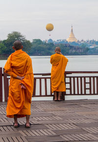 Rear view of men outside temple against building