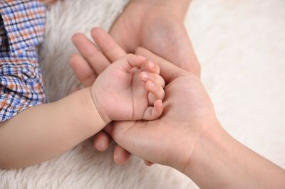 Close-up of hands on rug