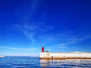 Port gate with red lighthouse and blue sky 