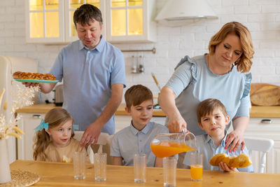 Young caucasian love family with children at table on table in kitchen who