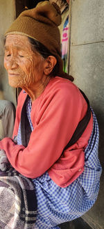 Side view of woman sitting outdoors