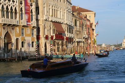 Boats in canal amidst buildings in city