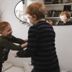 Rear view of boy standing in bathroom