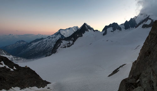 Scenic view of snowcapped mountains against sky during sunset