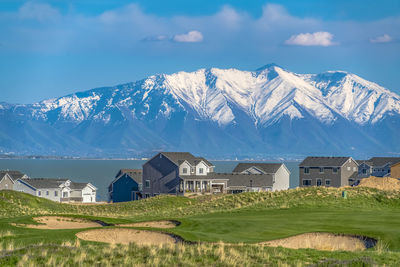 Houses on snowcapped mountain against sky