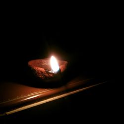 Close-up of lit candle in dark room